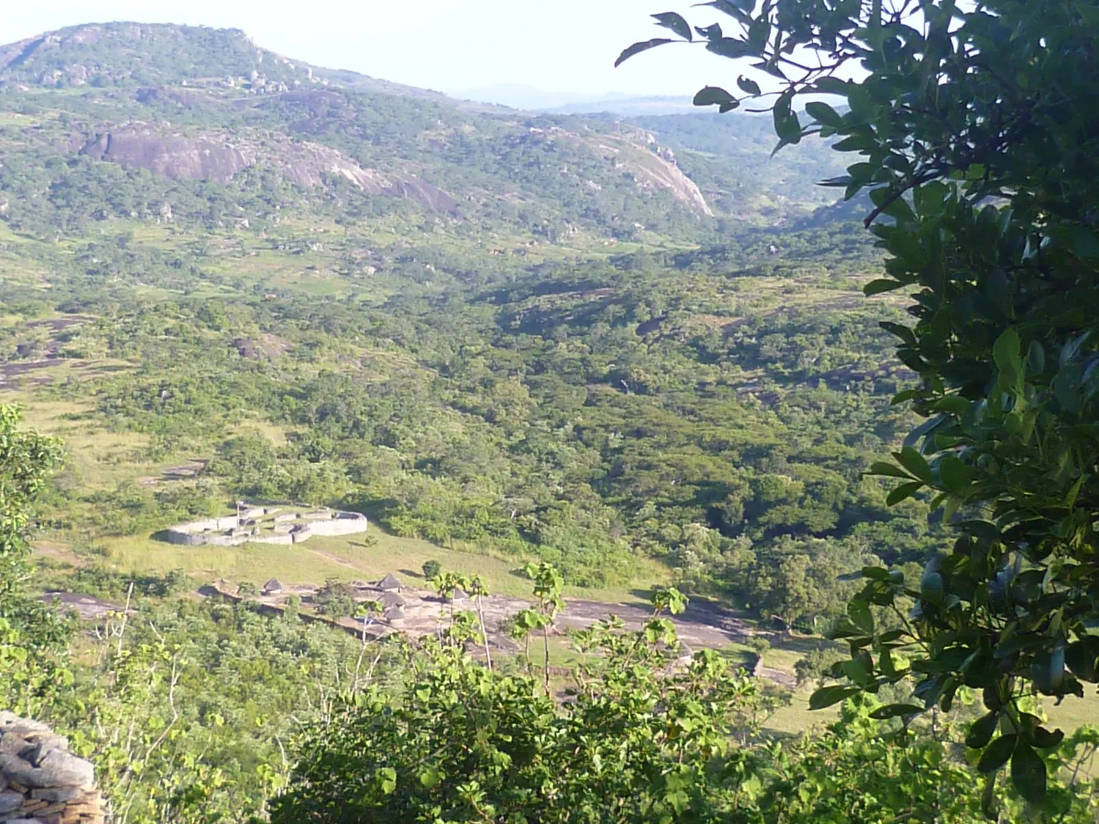 A wide valley of granite outcrops and green bush seen from high ground