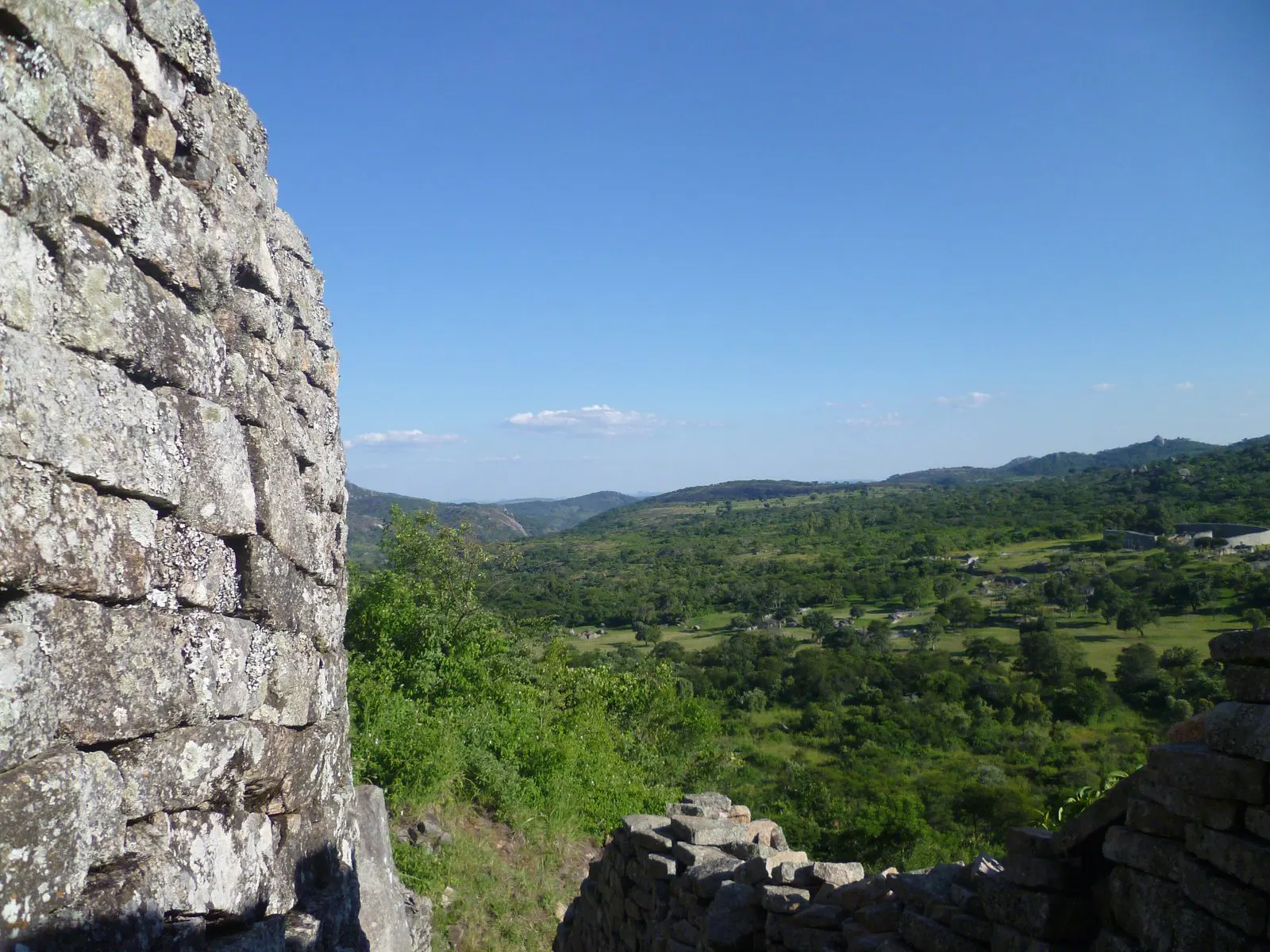 A wide Zimbabwean valley framed by bush, hills stretching to the horizon