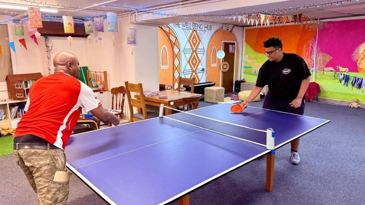 Table tennis being played in the main room at The Wellbeing Hub