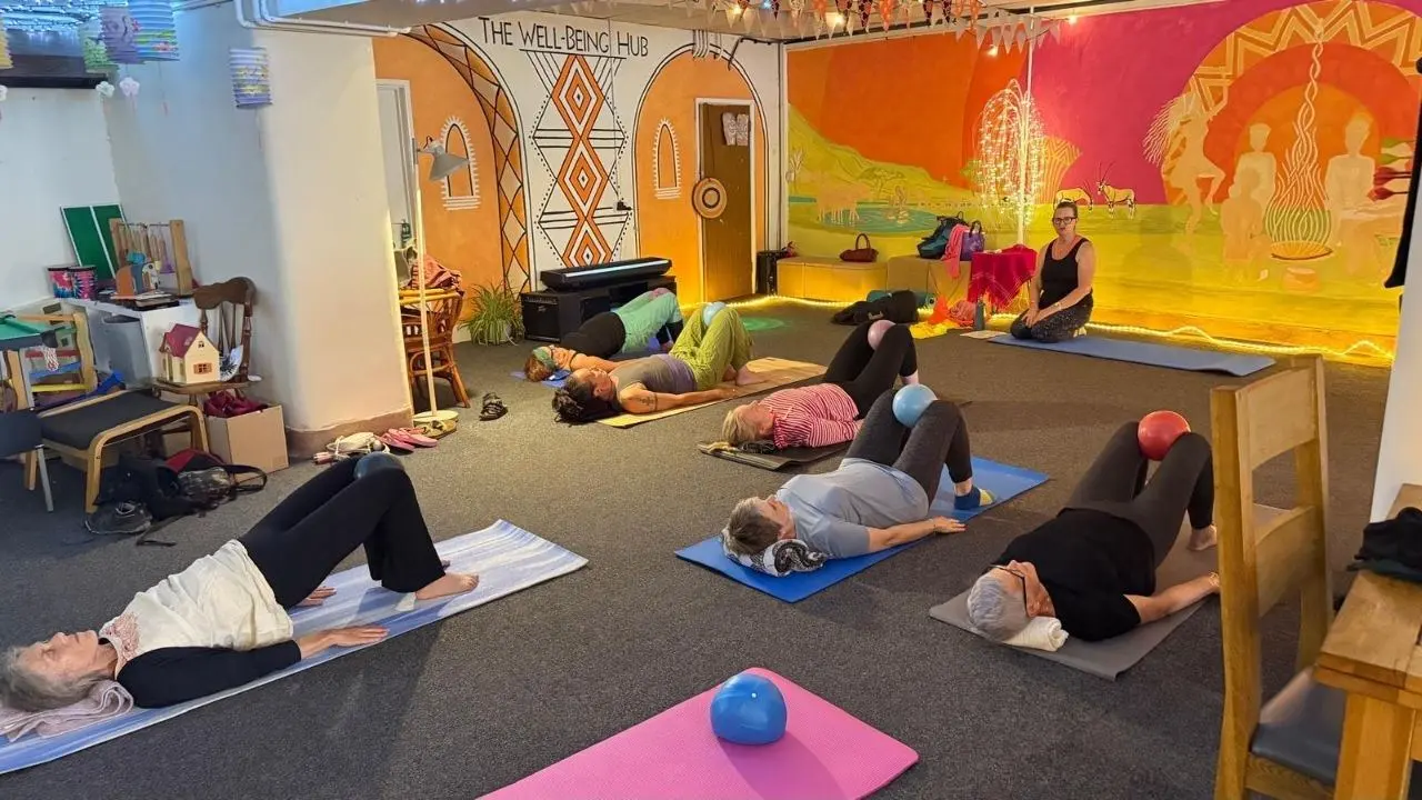 A group wellbeing class on mats at The Wellbeing Hub